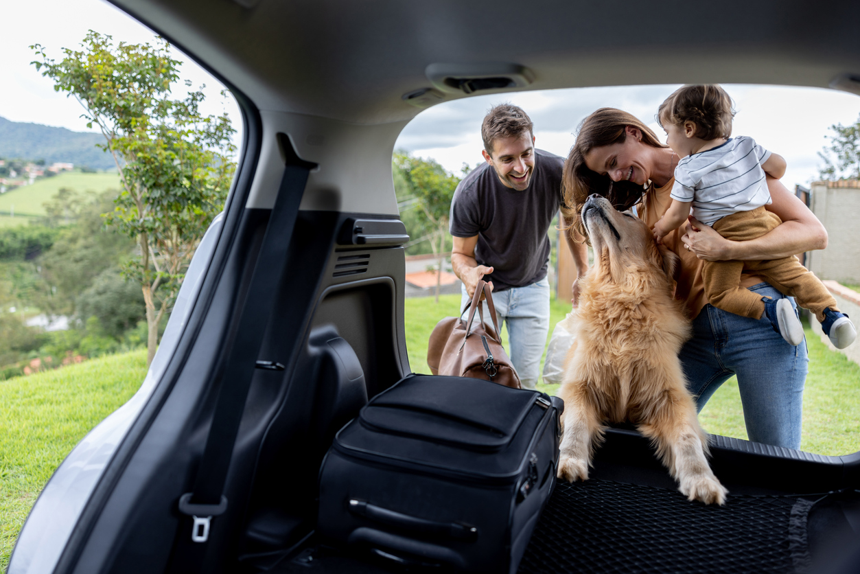 Family getting into their car with their dog