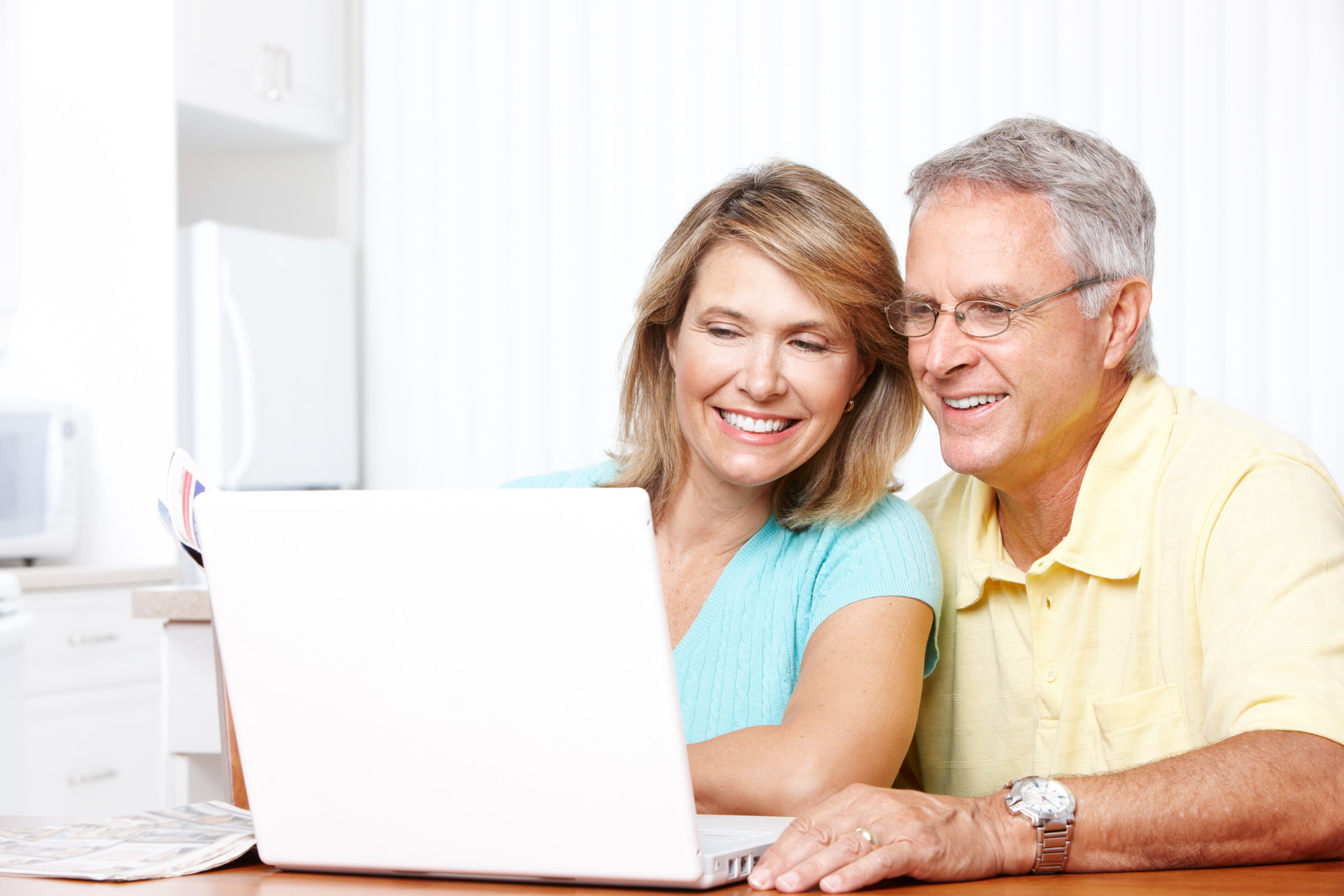 Middle aged couple smiling while looking at computer