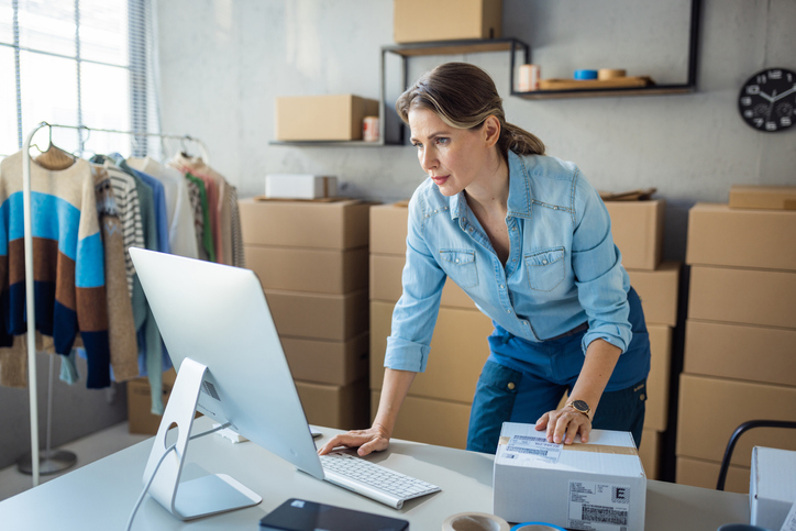 A woman at her small business on a computer