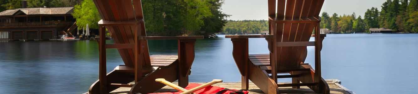 Two empty chairs on a deck at the lake